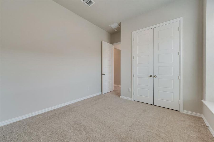 Unfurnished bedroom featuring light colored carpet and a closet