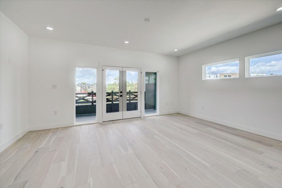 Game room has double French doors to a covered balcony.