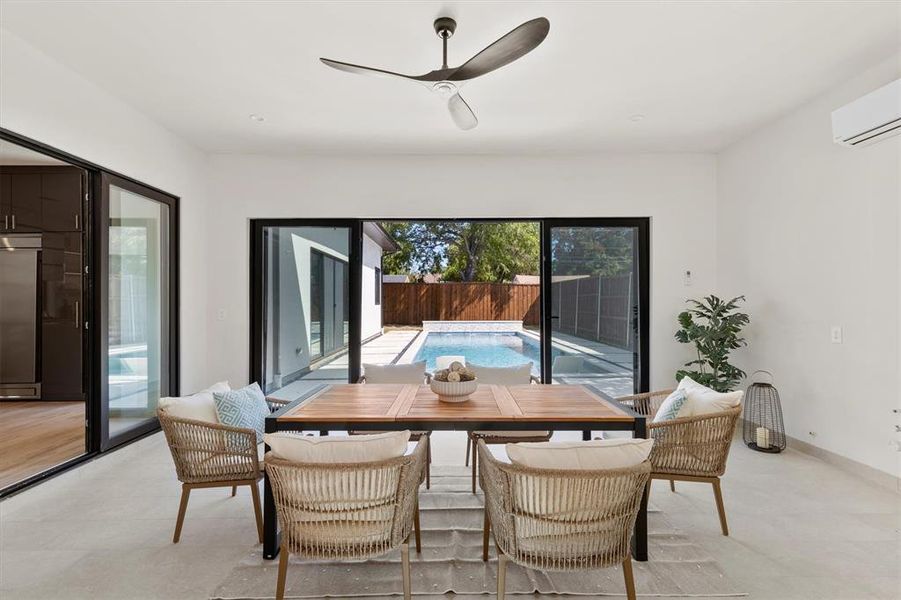 Dining space with a wall unit AC and ceiling fan