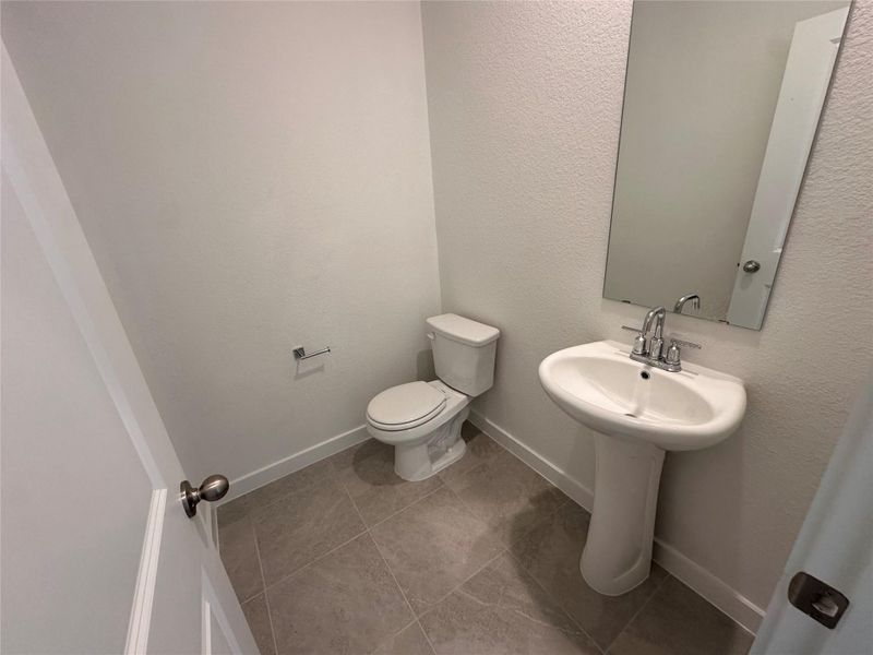 Bathroom featuring a textured wall and light tile patterned flooring Bathroom featuring a textured wall and light tile patterned flooring