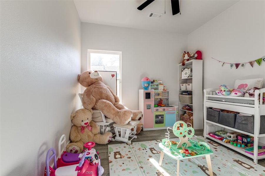 Rec room with visible vents, ceiling fan, and wood finished floors