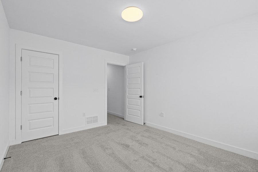 White-painted room featuring light gray carpet flooring and white trim