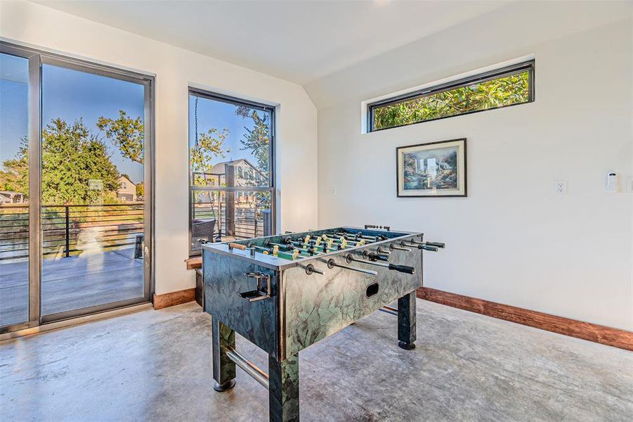 Playroom with finished concrete floors and vaulted ceiling