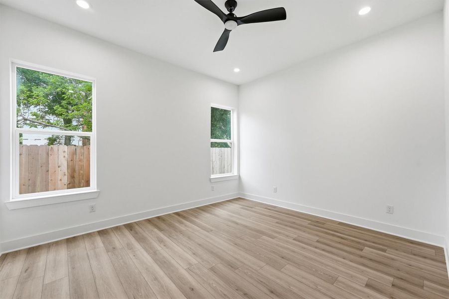 Versatile, sun-filled, and ready for whatever you need. This first-floor bedroom with large windows, recessed lighting, and a sleek black ceiling fan works beautifully as a guest room, home office, or private flex space. Versatile, sun-filled, and ready for whatever you need. This first-floor bedroom with large windows, recessed lighting, and a sleek black ceiling fan works beautifully as a guest room, home office, or private flex space.