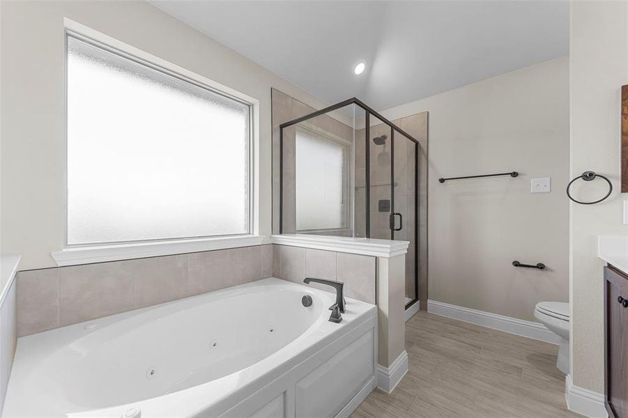 Full bathroom featuring a tub with jets, vanity, a shower stall, light wood-style flooring, and recessed lighting