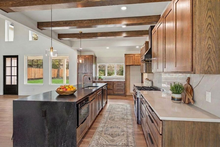 Soft-close cabinetry with designer drawer pulls, a built-in microwave, and a standout range—ideal for bringing your culinary creations to life.