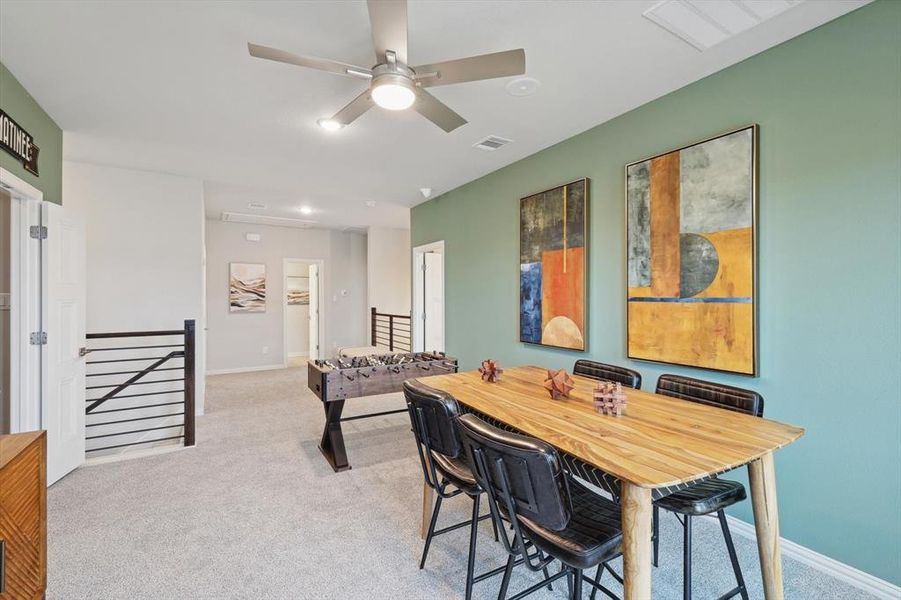 Dining space featuring light colored carpet and ceiling fan