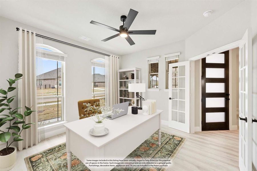 Home office with white desk, ceiling fan, built-in shelves, and French doors with large windows Home office with white desk, ceiling fan, built-in shelves, and French doors with large windows