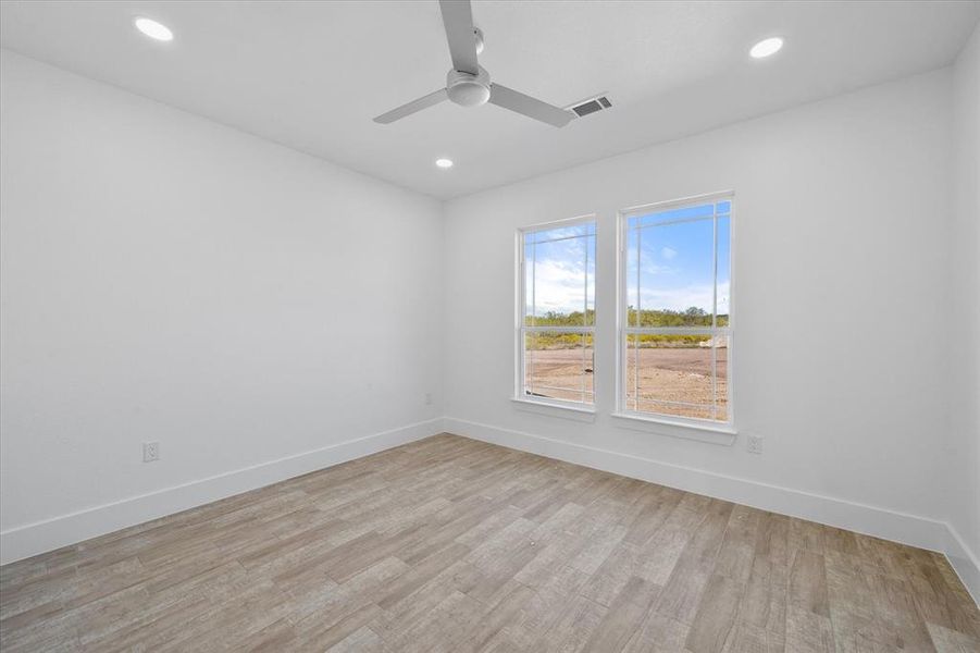 Empty room featuring light wood-type flooring and ceiling fan