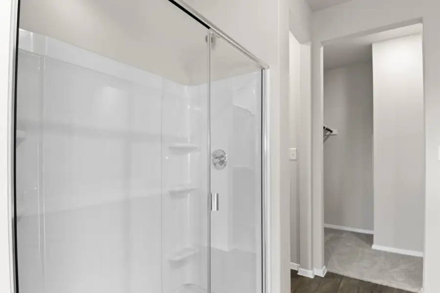 Image of primary bathroom with a walk-in shower and connecting walk-in closet