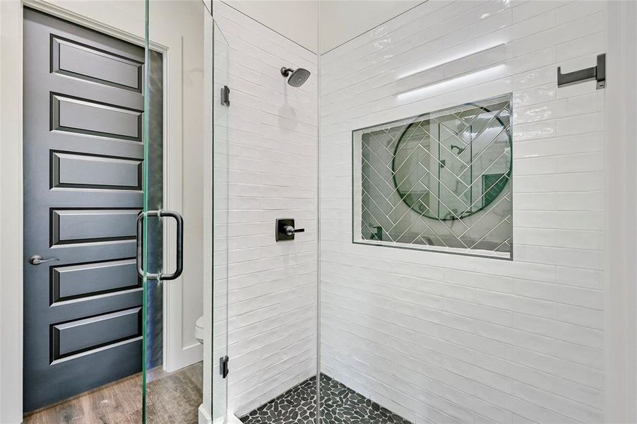 Bathroom with wood finished floors and a stall shower