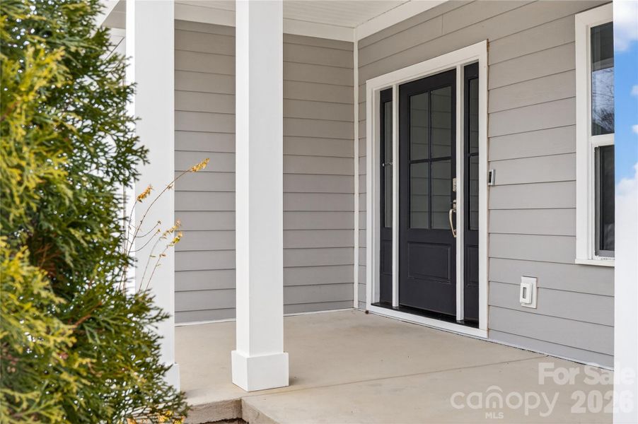 Covered Front Porch With concrete surface and white columns.