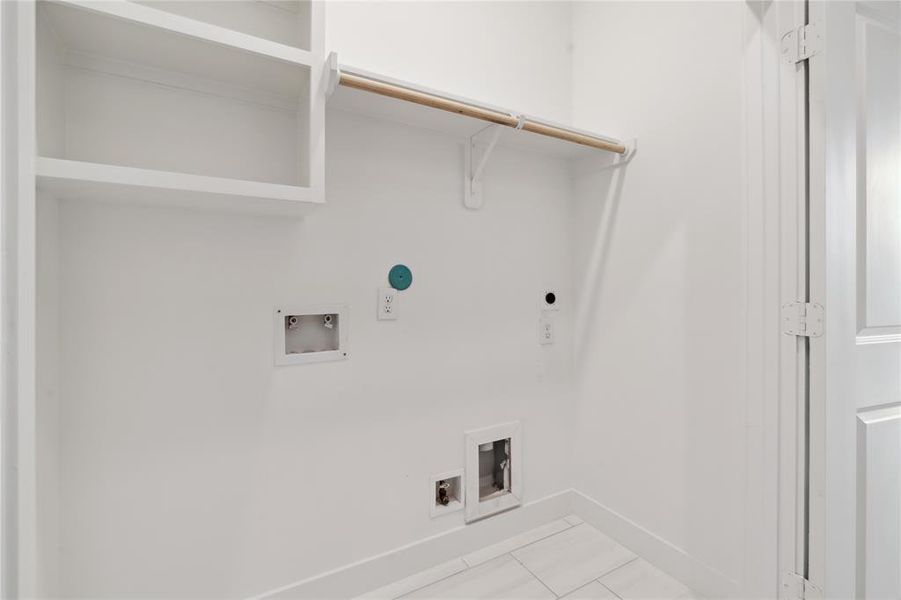 The walk in utility room that also features a hanging rack along with custom shelves.