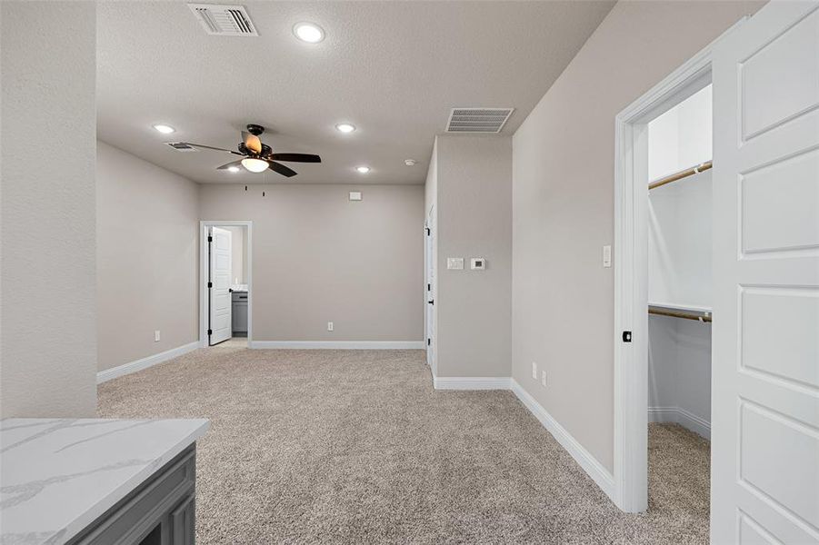 Empty room featuring ceiling fan and light carpet