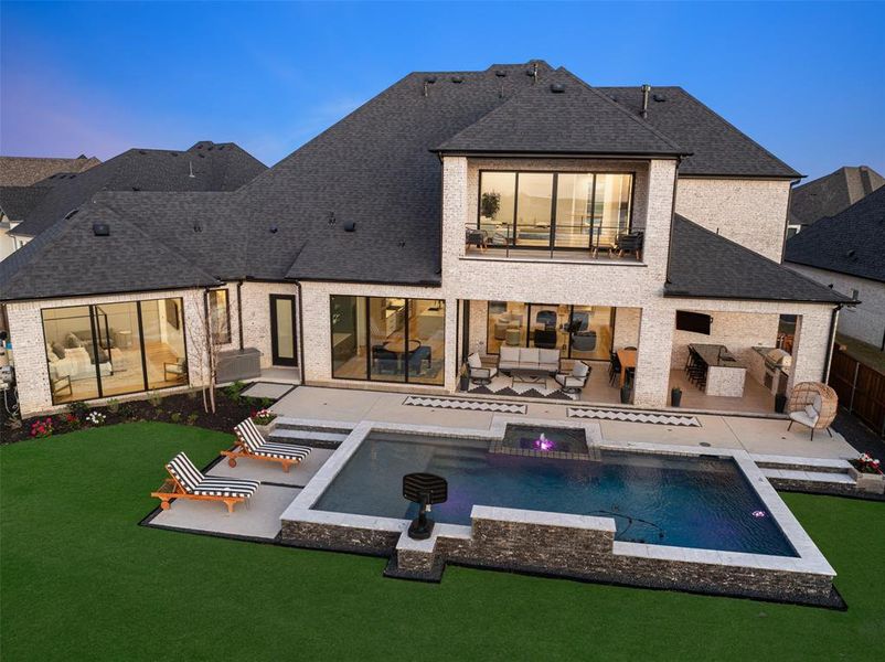 Stunning backyard oasis thoughtfully designed to capture the breathtaking lake views. Expansive windows across the back of the home highlight the architectural focus on the waterfront setting, seamlessly blending indoor and outdoor living.