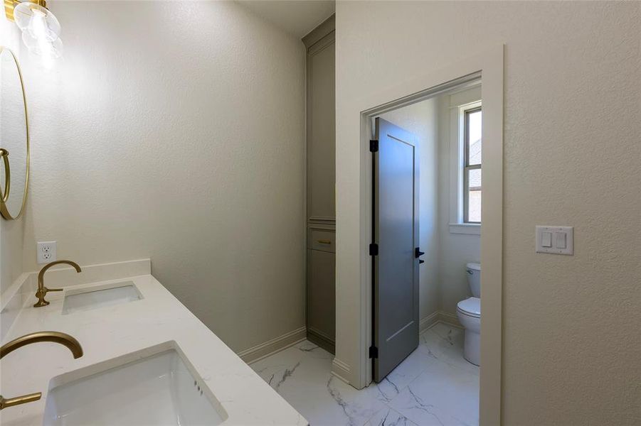 Bathroom with double vanity and light marble finish flooring Bathroom with double vanity and light marble finish flooring