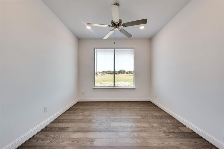 Unfurnished room with ceiling fan and light hardwood / wood-style floors