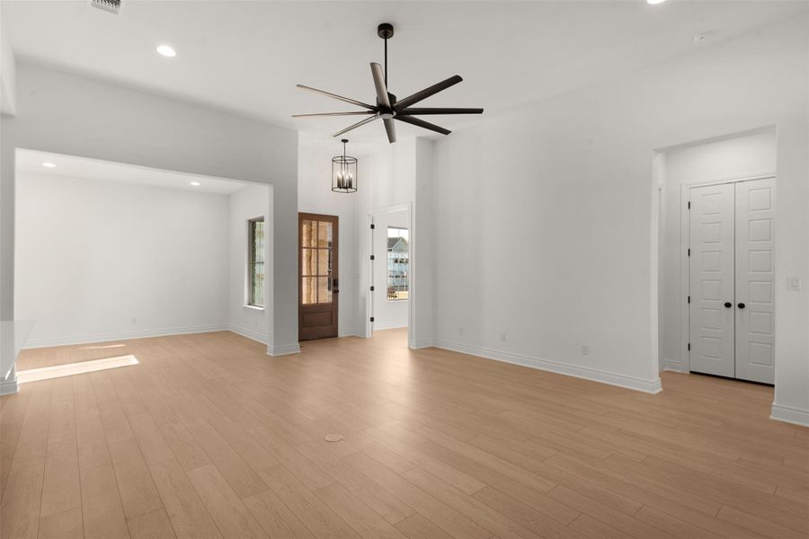 Unfurnished living room featuring a ceiling fan, recessed lighting, and light wood-style flooring