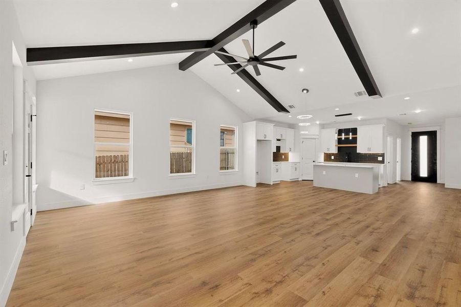Unfurnished living room with a ceiling fan, light wood-style flooring, and recessed lighting Unfurnished living room with a ceiling fan, light wood-style flooring, and recessed lighting