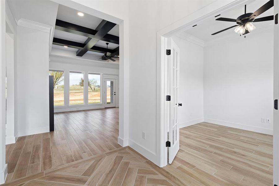 Corridor featuring light hardwood / wood-style floors, ornamental molding, beamed ceiling, and coffered ceiling