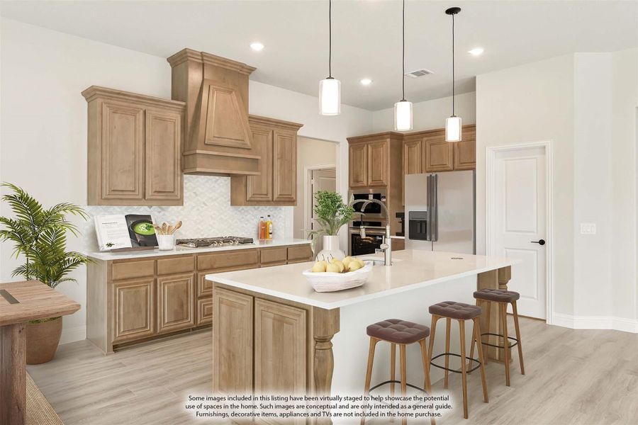 Kitchen with light wood cabinets, center island with seating, pendant lights, and stainless steel appliances