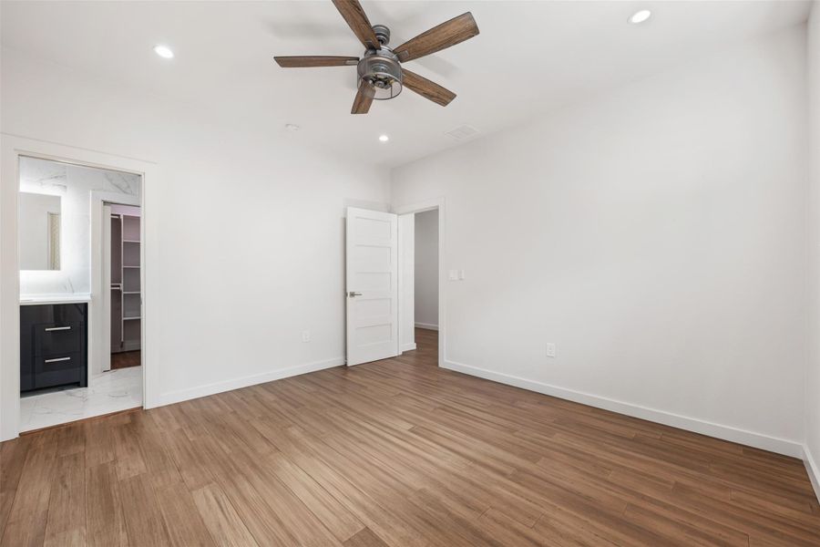 Unfurnished bedroom with a ceiling fan, recessed lighting, light wood-style flooring, and a spacious closet