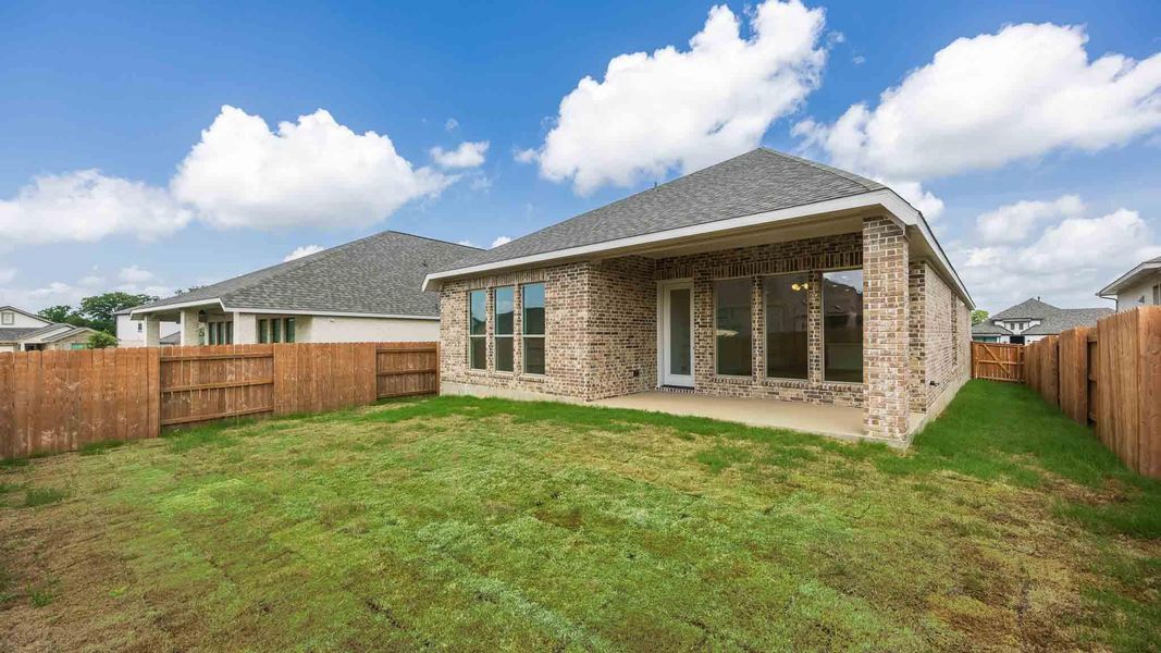 Back of property with brick siding, a fenced backyard, a patio, and a shingled roof Back of property with brick siding, a fenced backyard, a patio, and a shingled roof