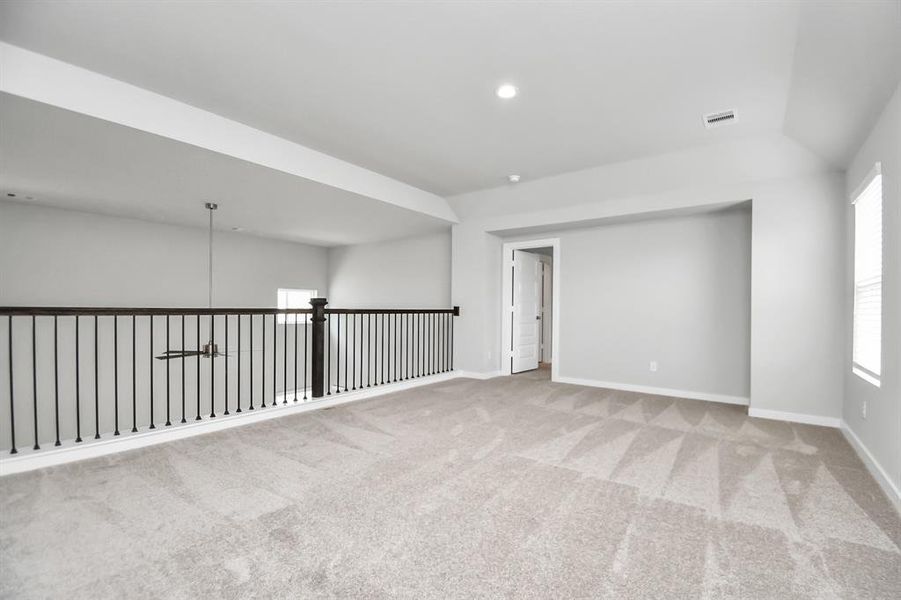 Ascend to relaxation in this fantastic game room! Ideal for both casual gatherings and adult gaming, it boasts plush carpet, lofty ceilings, custom paint, and ample windows for abundant natural light.