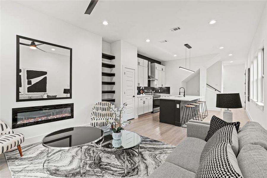 Living room featuring ceiling fan, sink, and light hardwood / wood-style flooring