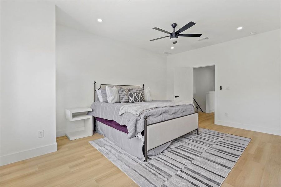 Bedroom featuring light wood-style flooring, recessed lighting, and a ceiling fan Bedroom featuring light wood-style flooring, recessed lighting, and a ceiling fan