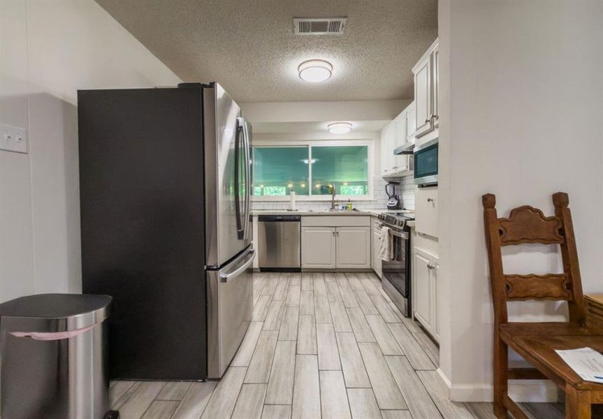 Modern galley kitchen with light wood-finish flooring