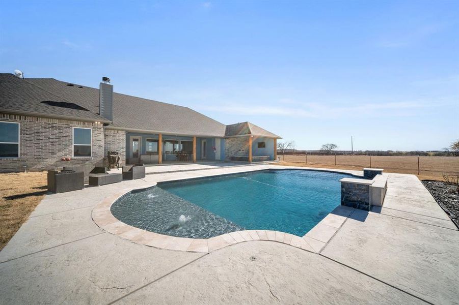 Swimming pool with a patio area, a fenced backyard, and outdoor seating