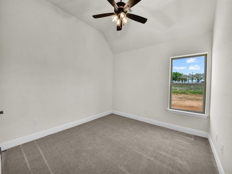 Bonus room with baseboards, lofted ceiling, carpet, and a ceiling fan Bonus room with baseboards, lofted ceiling, carpet, and a ceiling fan