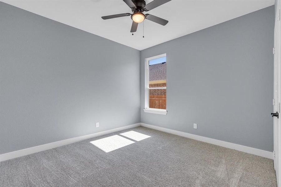 Spare room featuring carpet flooring and ceiling fan