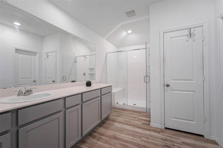 Dual vanities, a massive mirror, and an oversized walk-in shower with bench highlight this spa-inspired ensuite. Dual vanities, a massive mirror, and an oversized walk-in shower with bench highlight this spa-inspired ensuite.