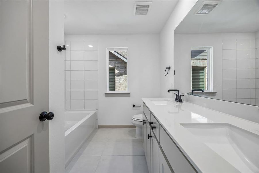 Guests will enjoy their own vanity space in this thoughtfully designed guest bath.