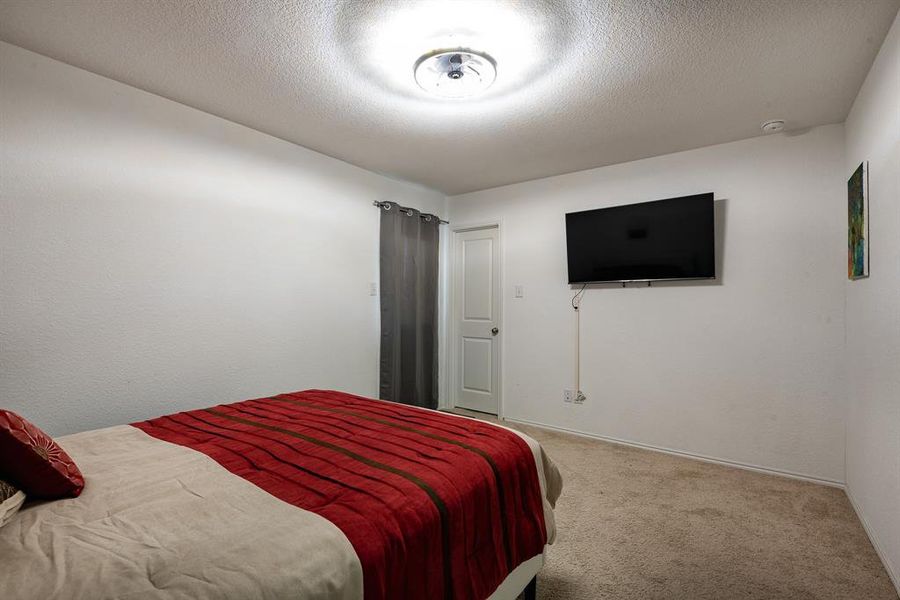 Carpeted bedroom with a textured ceiling