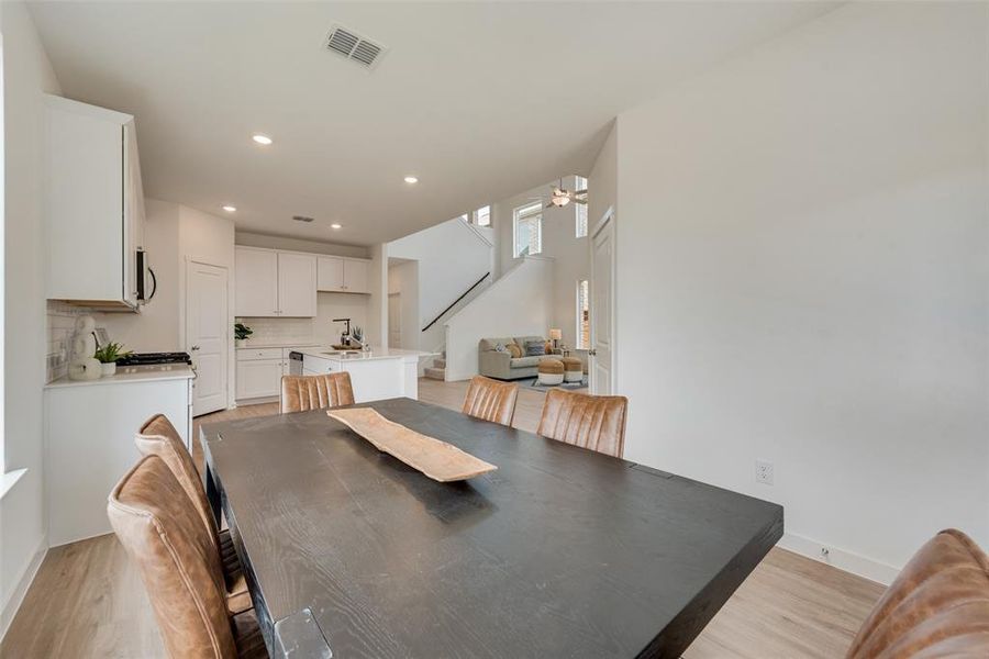 Dining area featuring sink, light wood-type flooring, and ceiling fan