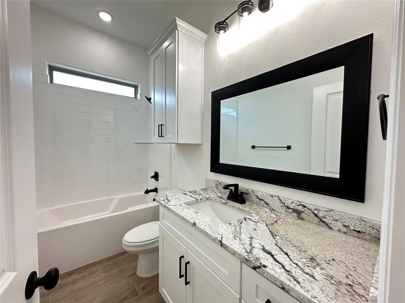 Full bathroom featuring vanity,  shower combination, and dark wood-type flooring