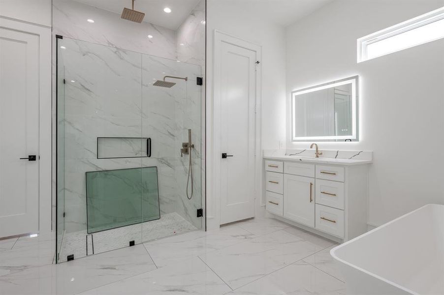 Full bathroom with a marble finish shower, light marble finish flooring, vanity, a freestanding bath, and recessed lighting Full bathroom with a marble finish shower, light marble finish flooring, vanity, a freestanding bath, and recessed lighting