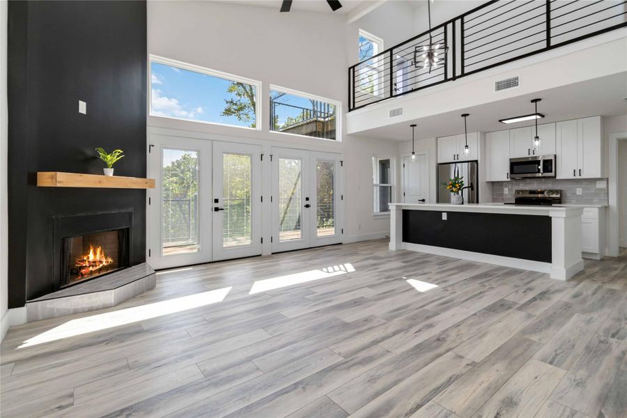 Wood-burning black-accent fireplace anchors the space while French doors and clerestory windows flood the home with natural light Wood-burning black-accent fireplace anchors the space while French doors and clerestory windows flood the home with natural light
