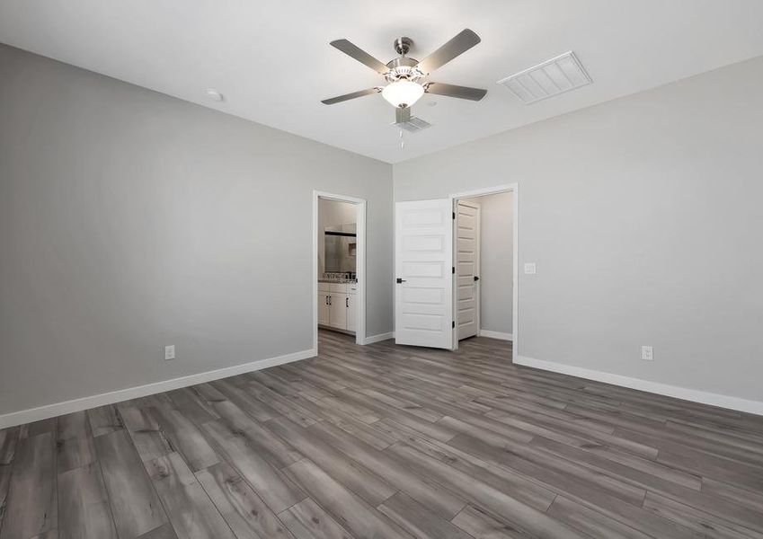 Master bedroom with a ceiling fan and attached master bathroom.