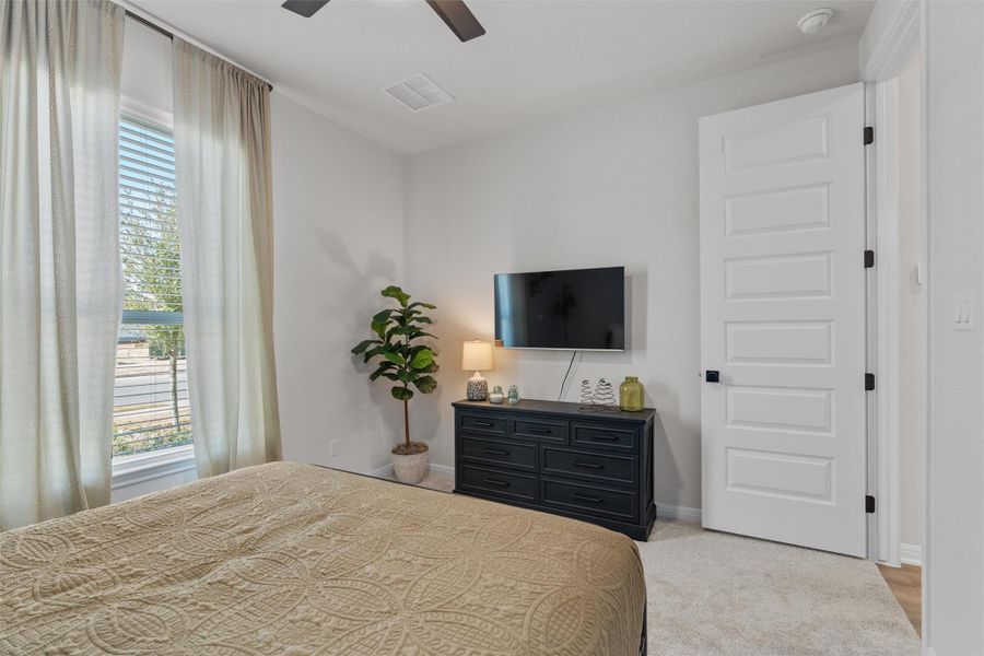 Bedroom with ceiling fan and light colored carpet