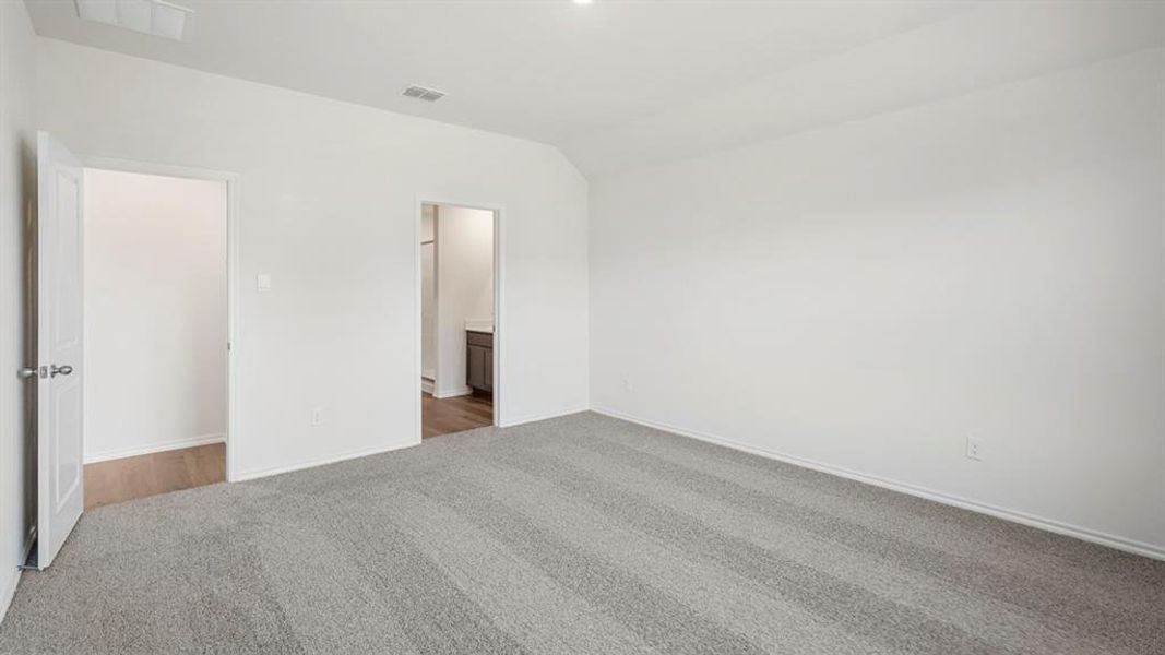Spacious room featuring light gray patterned carpet and bright white walls