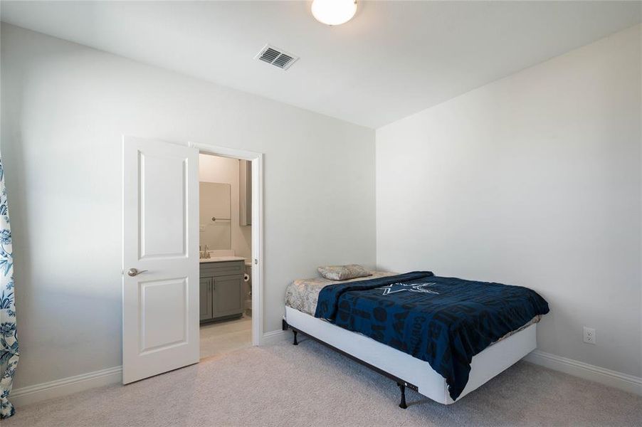 Cooling ceiling fan and ensuite bath in primary bedroom.