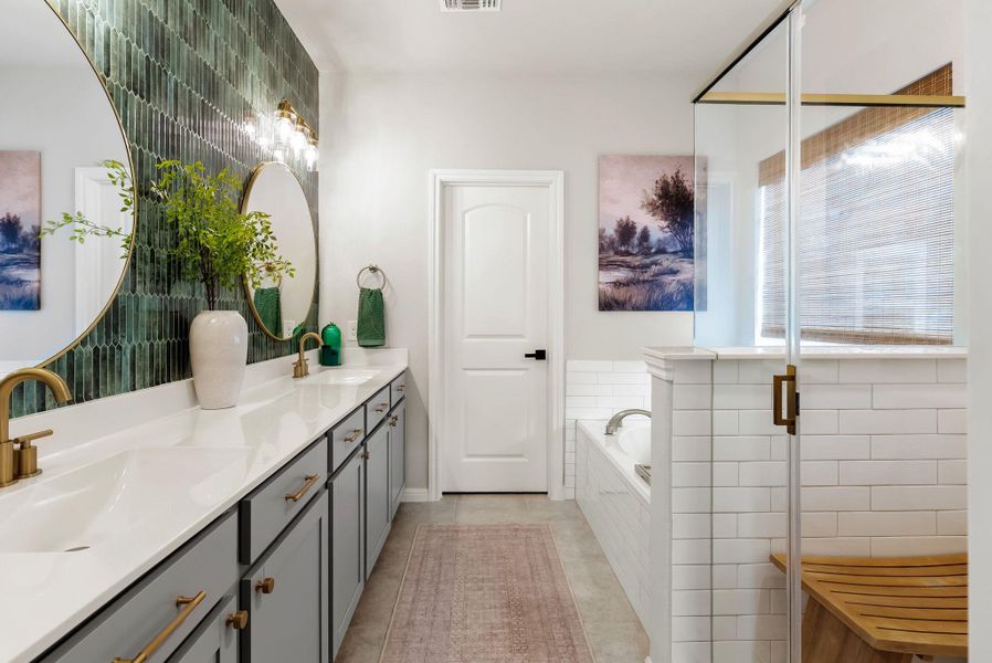 Bathroom featuring double vanity, a garden tub, and a stall shower