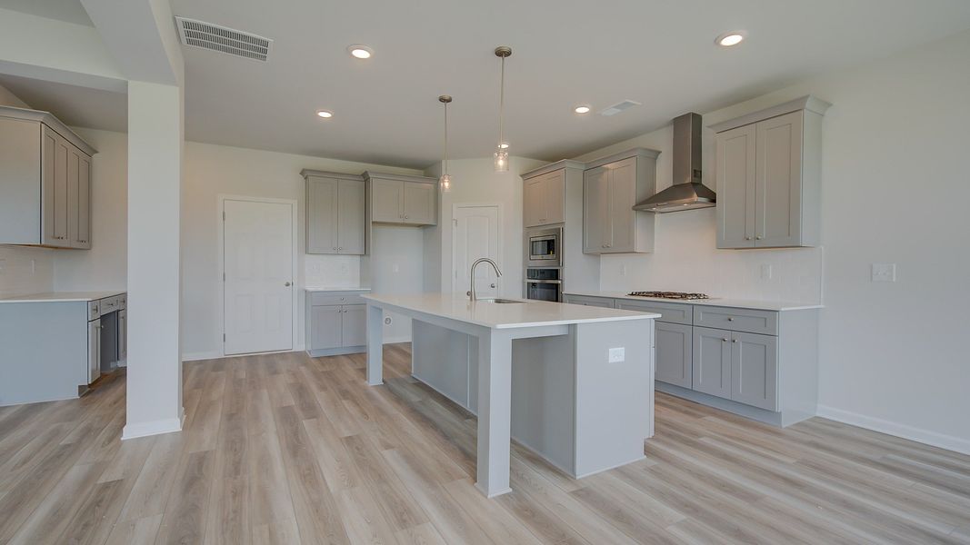 Modern kitchen with neutral cabinetry and oversized island in the Clarity at Brighton in Locust Grove, GA.