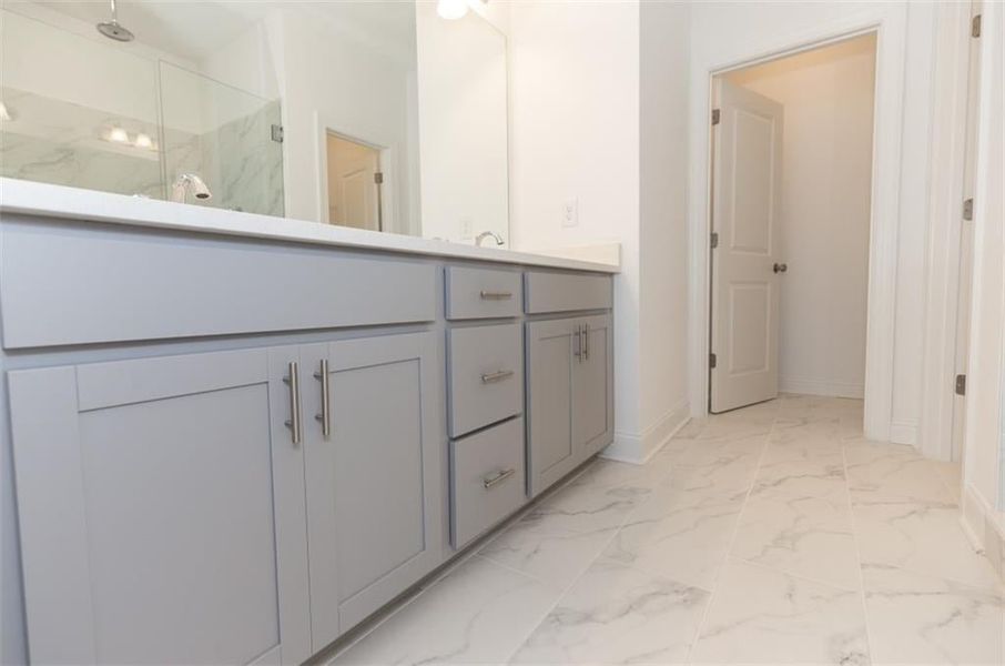 Bathroom with walk in shower, tile floors, and vanity