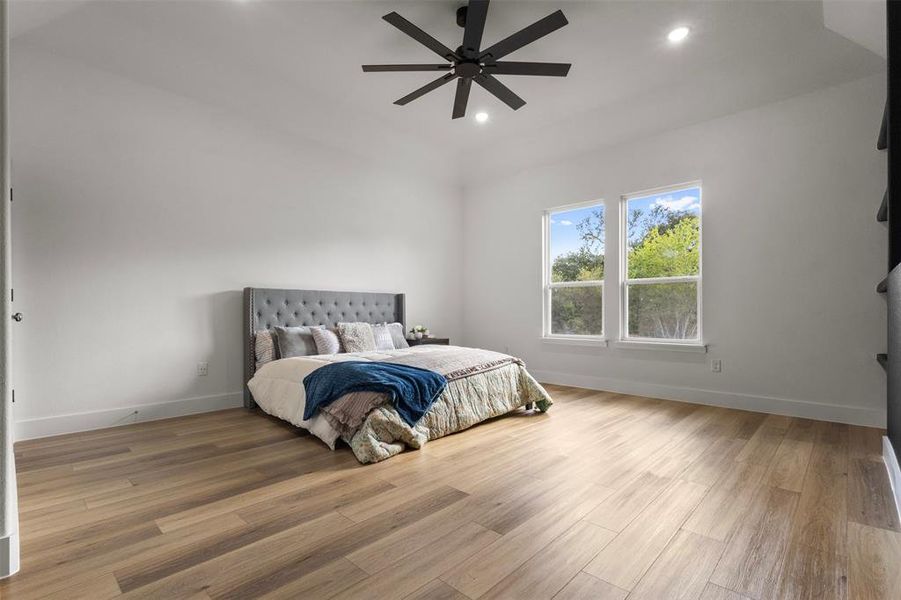Bedroom with light wood finished floors, a ceiling fan, and recessed lighting