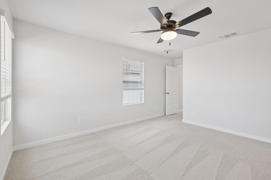 A room with a ceiling fan and a door.